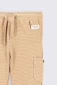 Дитячі бавовняні штани Coccodrillo колір бежевий однотонні (2676835)