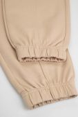 Дитячі бавовняні штани Coccodrillo колір бежевий однотонні (3477834)